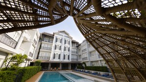Uma área de piscina com vista clara dos edifícios ao redor, incluindo uma estrutura alta e com várias andares e varandas.