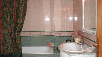 A bathroom with a bathtub, sink, and mirror.