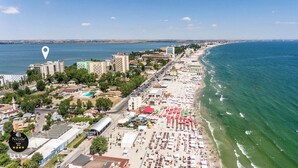 Un paisaje urbano costero con playa, edificios y puerto deportivo.