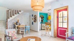Amplia sala de estar con escalera, comedor y cocina.