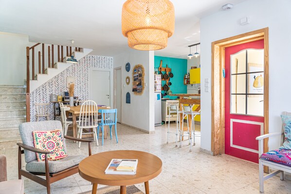 A spacious living area with a staircase, a dining area, and a kitchen. - The White Hill Guest House - Hostel (Ramat Negev)
