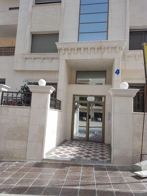 Stunning entrance with a central staircase and glass door, flanked by two columns.