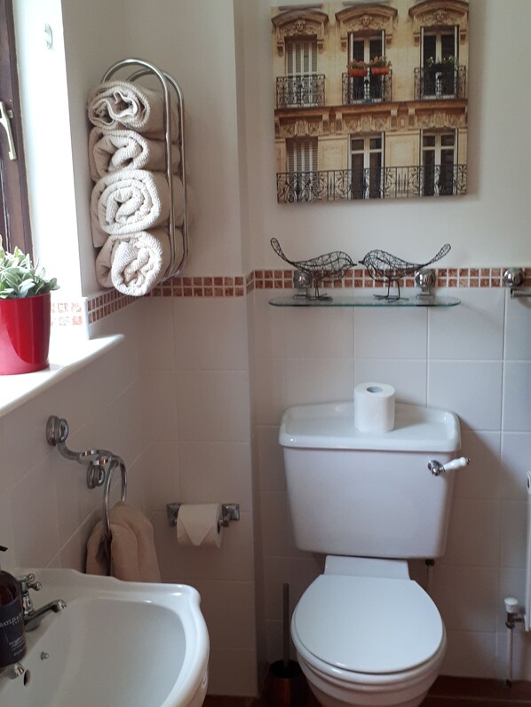 A bathroom with a toilet, sink, and towel rack. - Faithlegg Lodge (Faithlegg)