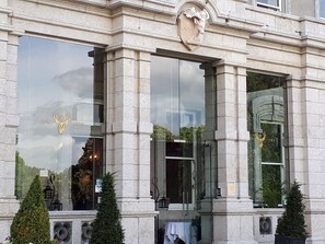 A building with large windows, stone columns, and a crest above the entrance. - Faithlegg Lodge (Faithlegg)