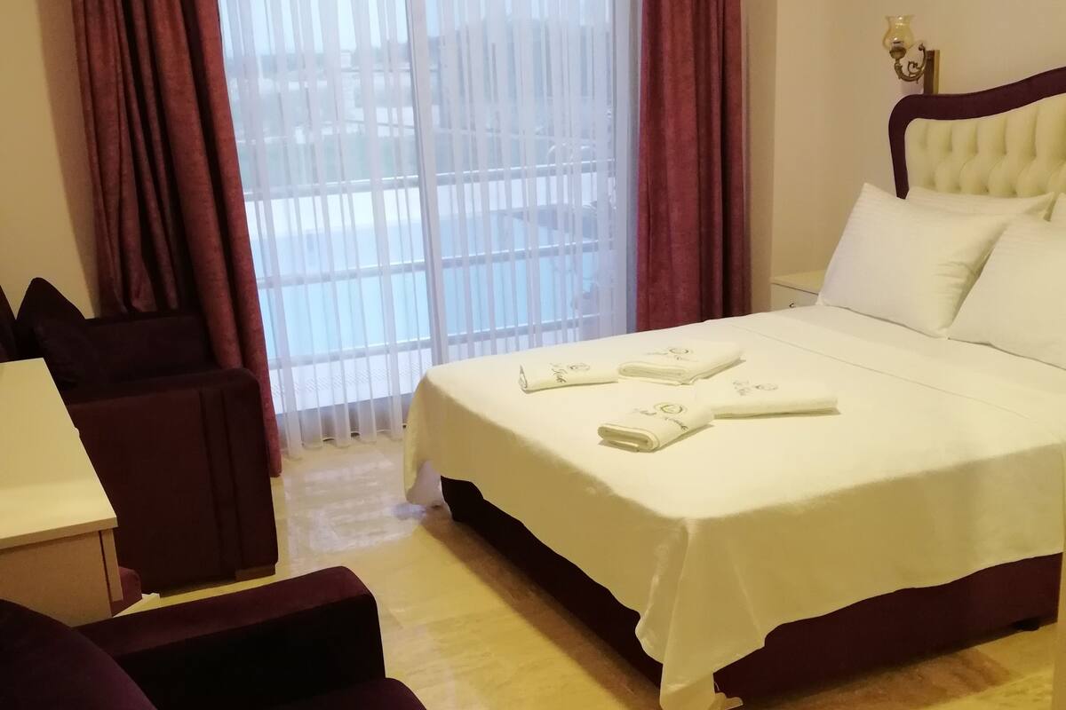 A hotel room with a bed, a desk, and a chair.