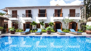 A hotel with a swimming pool, lounge chairs, and potted plants. - La Casita Saigon (Ho Chi Minh City)