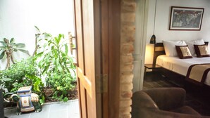 A room with a bed, a nightstand, and a small potted plant. - La Casita Saigon (Ho Chi Minh City)