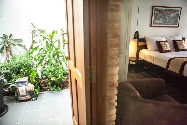 A room with a bed, a nightstand, and a small potted plant.
