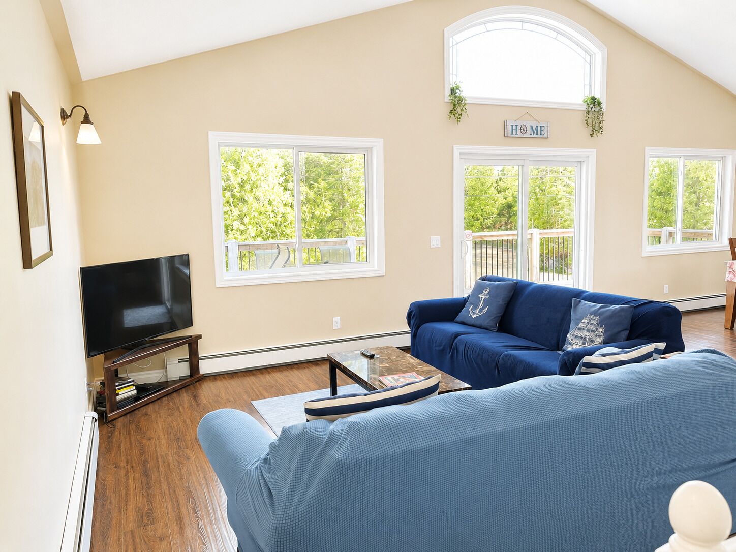 A living room with a TV, a blue sofa, and a coffee table.
