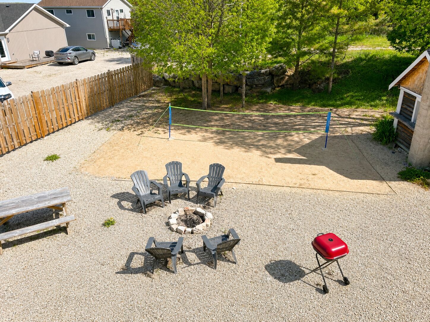 Patio trasero con un brasero, mobiliario exterior y una parrilla de barbacoa.