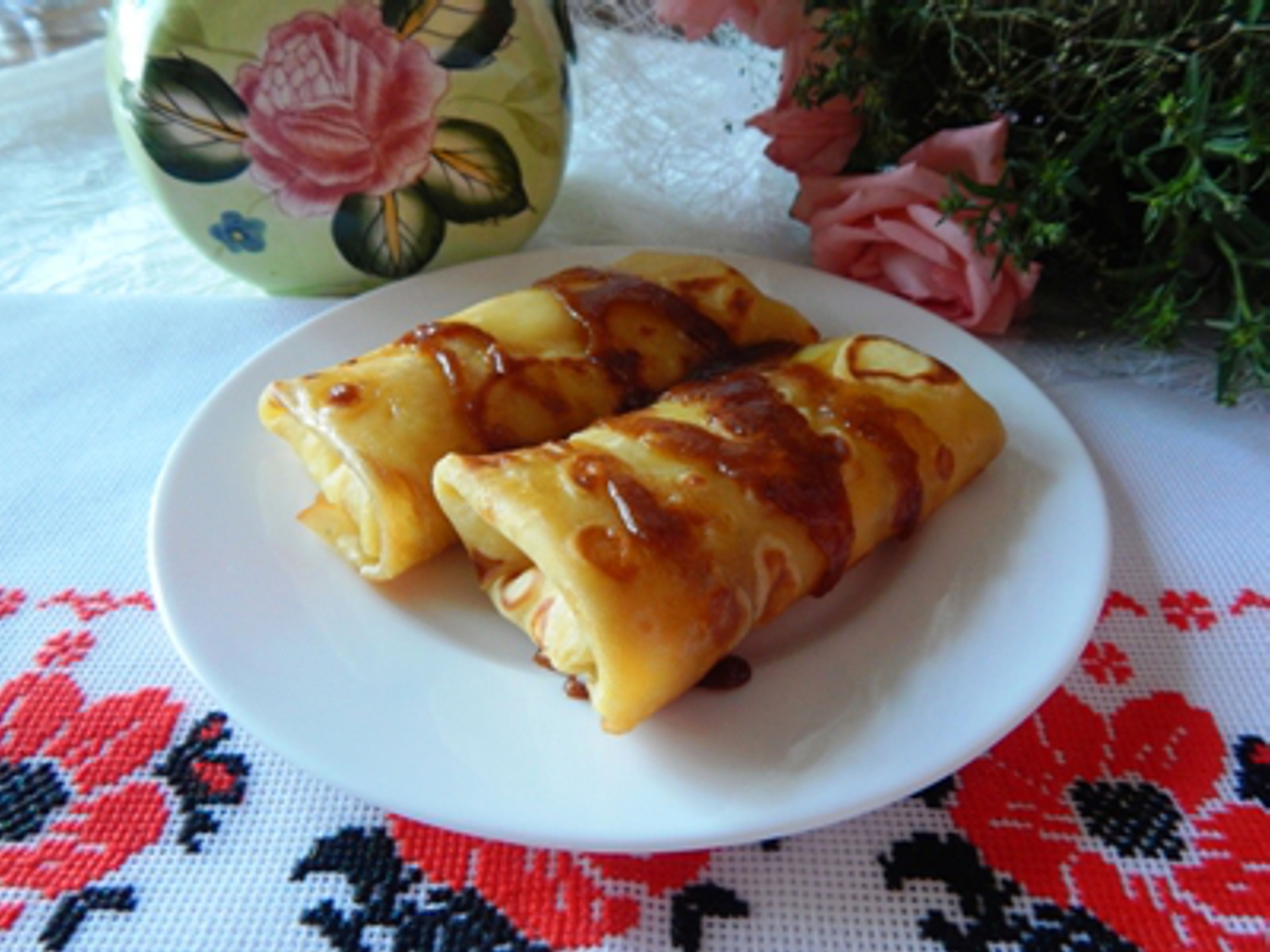 A plate with two pastries on a tablecloth with a floral pattern.
