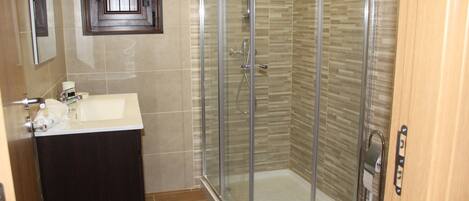Un bagno con doccia vetrata, lavandino con specchio e WC.