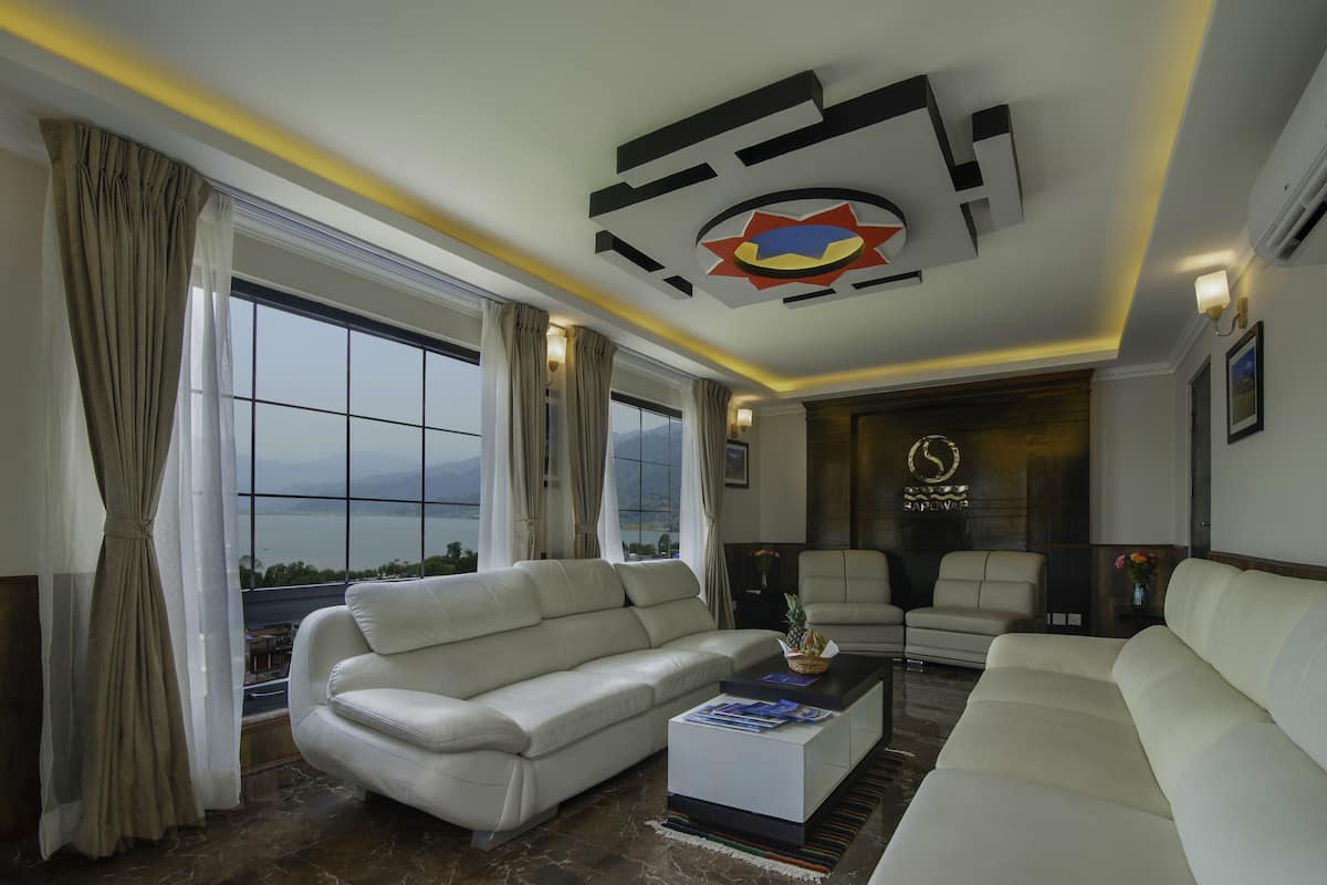 A modern living room with a white sofa, a coffee table, and a view of the outdoors.