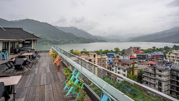 A terrace with outdoor seating overlooking a river and hills. - Hotel Sarowar Pokhara-Luxury Hospitality in the Heart of Pokhara (Pokhara)