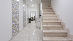 A modern interior with a staircase leading to a reception area. - TH Collection Rooms (Oristano)