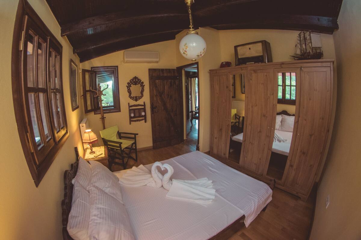Un dormitorio con una cama grande, un armario de madera y una mesita de noche con lámpara.