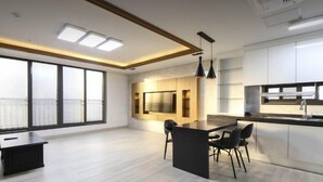 A modern kitchen with a central island, large windows, and a dining area. - G&G Hotel (Busan)