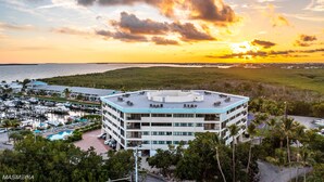 A hotel with a rooftop pool, surrounded by lush greenery and a marina. - Penthouse Apartment Sunsets in Key Largo, Kawama Yacht Club Tower (Key Largo)