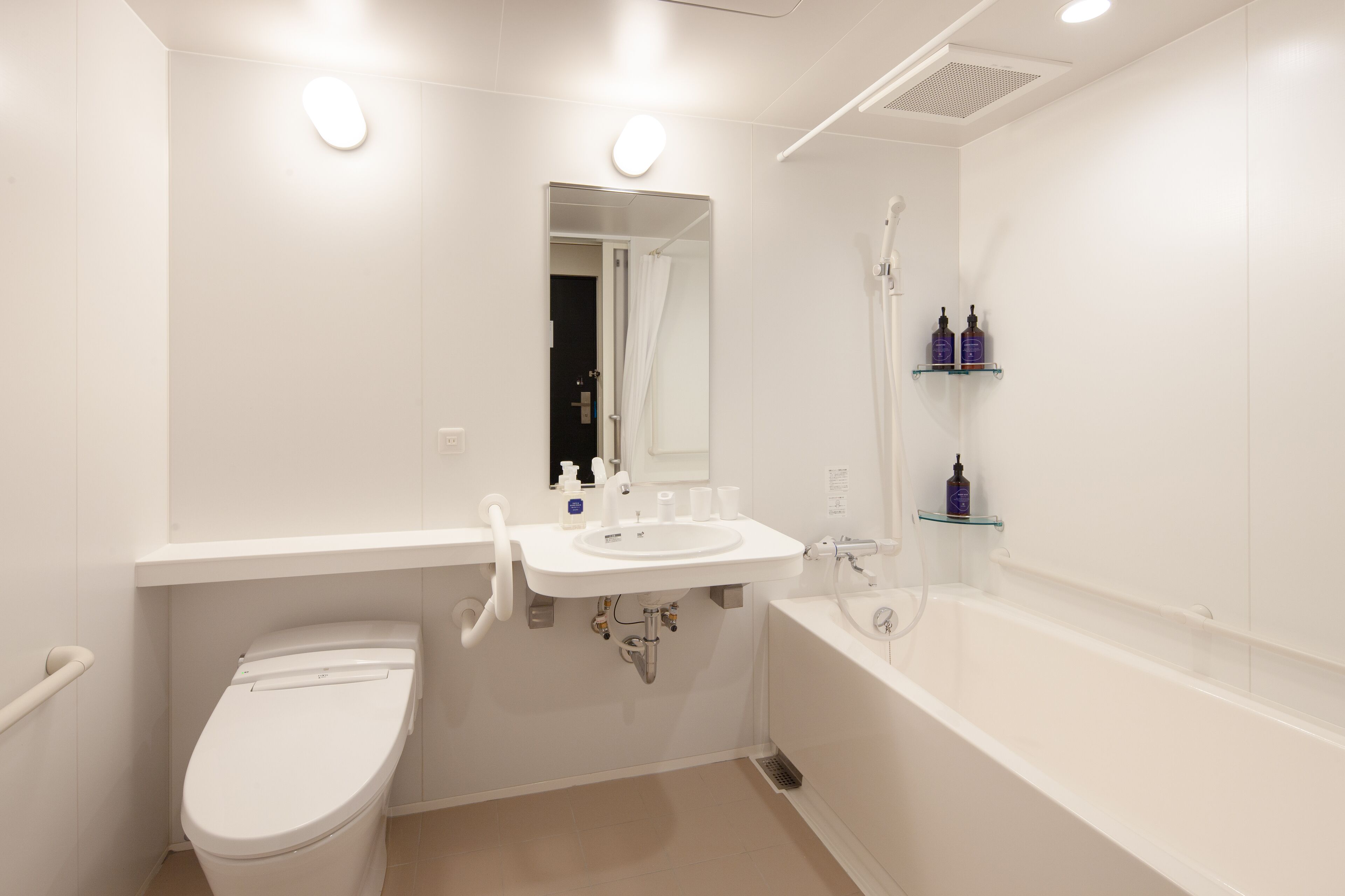 Een moderne badkamer met toilet, wastafel en bad.