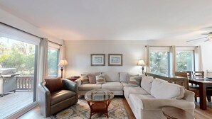 A living room with a sofa, armchairs, a coffee table, and a dining area with a table and chairs. - Short walk or bike ride to the beach and Palmetto Dunes golf! (Hilton Head)