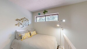 A bedroom with a bed, a window, and a wall-mounted decoration. - Short walk or bike ride to the beach and Palmetto Dunes golf! (Hilton Head)
