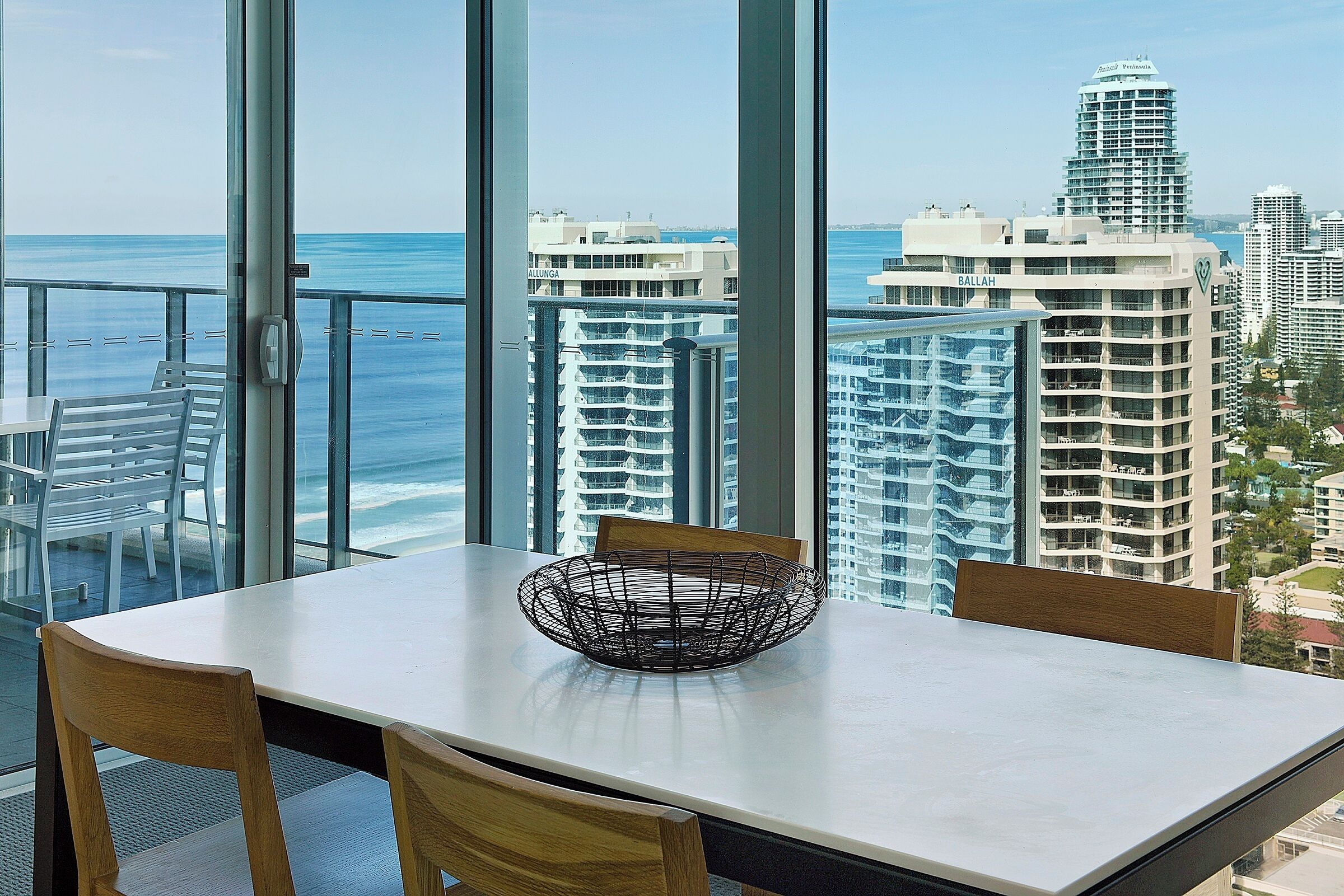 A dining area with a view of the ocean and cityscape.