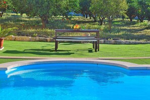 Alberca al aire libre y camastros