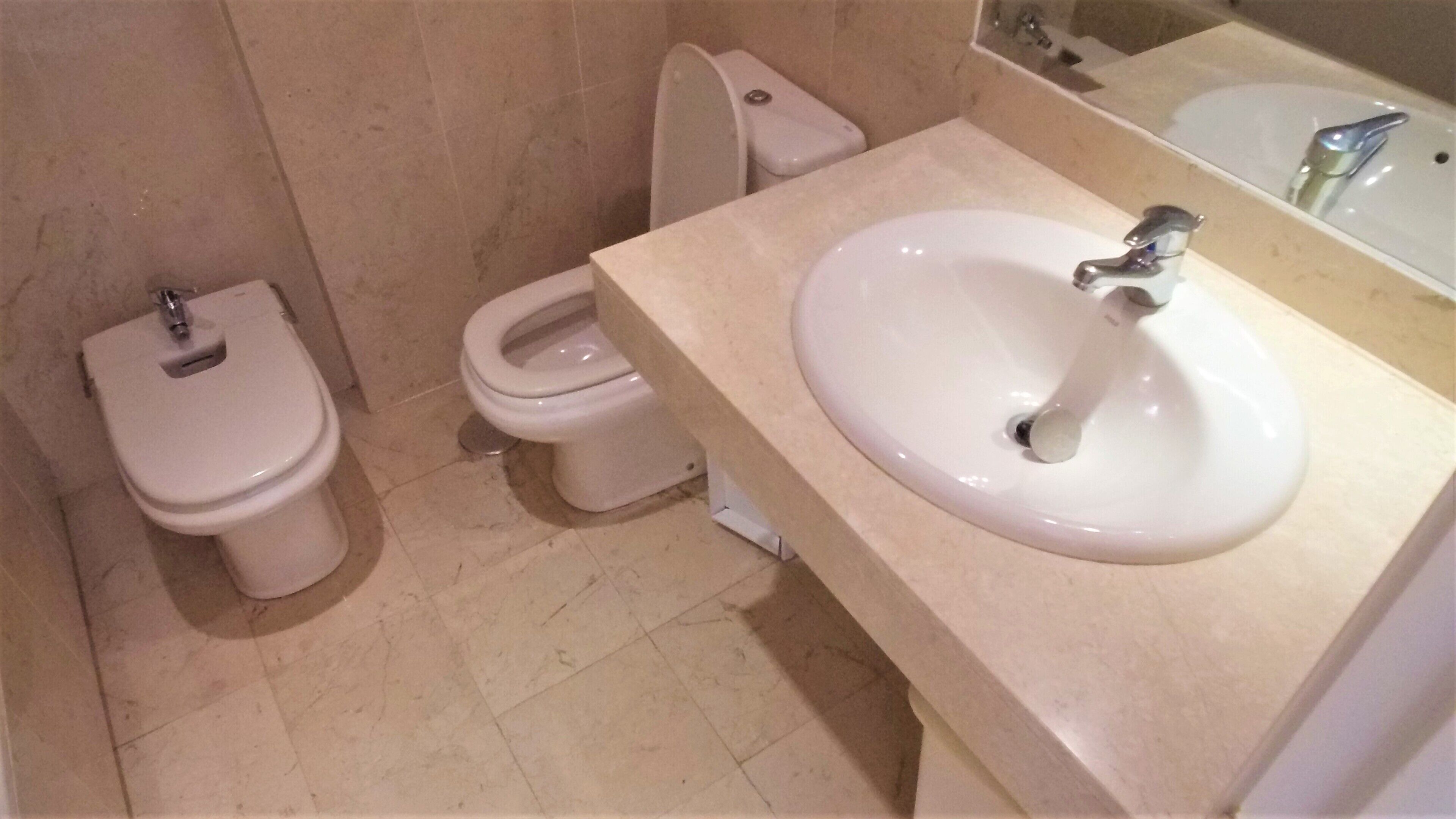 Un bagno con toilette, bidet e lavandino.