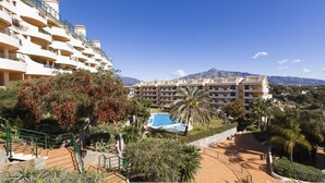 Ein Hotel mit mehreren Balkonen, einem Schwimmbad und Bergblick.
