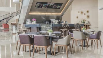 A modern dining area with a central table, surrounding chairs, and a menu board above.