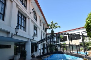 Una piscina al aire libre, sillones reclinables de piscina