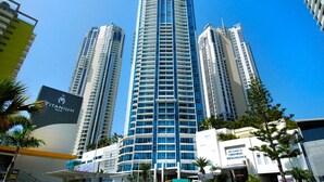 Un hotel moderno de gran altura, con múltiples balcones y un llamativo letrero que anuncia 'Titanium Bar'.