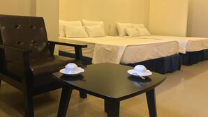 A hotel room with a single bed, a chair, and a table with two cups and saucers. - Hotel Pure (Hai Phong)