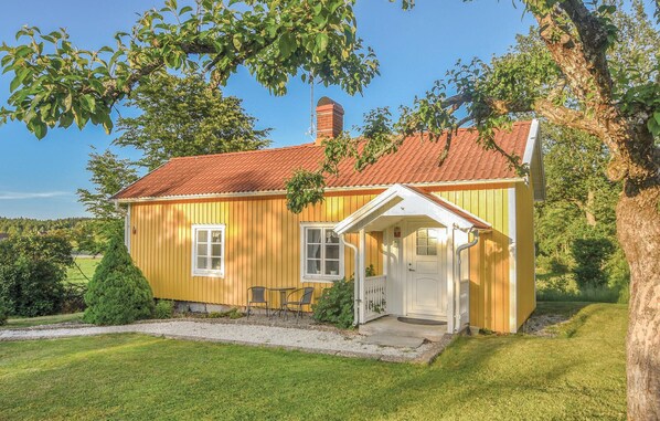 A yellow wooden house with a red roof, a small porch, and a chimney. - Awesome home in åsensbruk with kitchen (Åsensbruk)