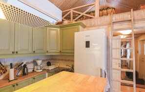 A kitchen with green cabinets, a white Samsung refrigerator, a wooden table, and a ladder leading to a lofted sleeping area. - Awesome home in åsensbruk with kitchen (Åsensbruk)