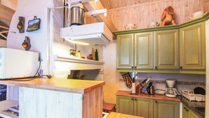 Una cocina con armarios de madera, una estufa y varios utensilios de cocina.