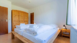 Una camera da letto con un letto in legno, un comodino con una lampada e un armadio.