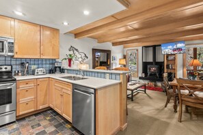 A modern kitchen with wooden cabinets, a built-in dishwasher, and a central island. - RMR: La Choumine 8 Condo in Teton Village / Steps from the Mountain! (Teton Village)