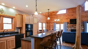 Ein Blockhaus-Interieur mit Küche, Essbereich und Wohnzimmer.