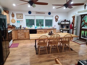 Enjoy meals in the well-appointed kitchen and dining area with a central island, wooden cabinets, and a dining table for four.