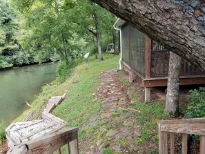 Enjoy a serene retreat surrounded by lush greenery and a calm body of water.