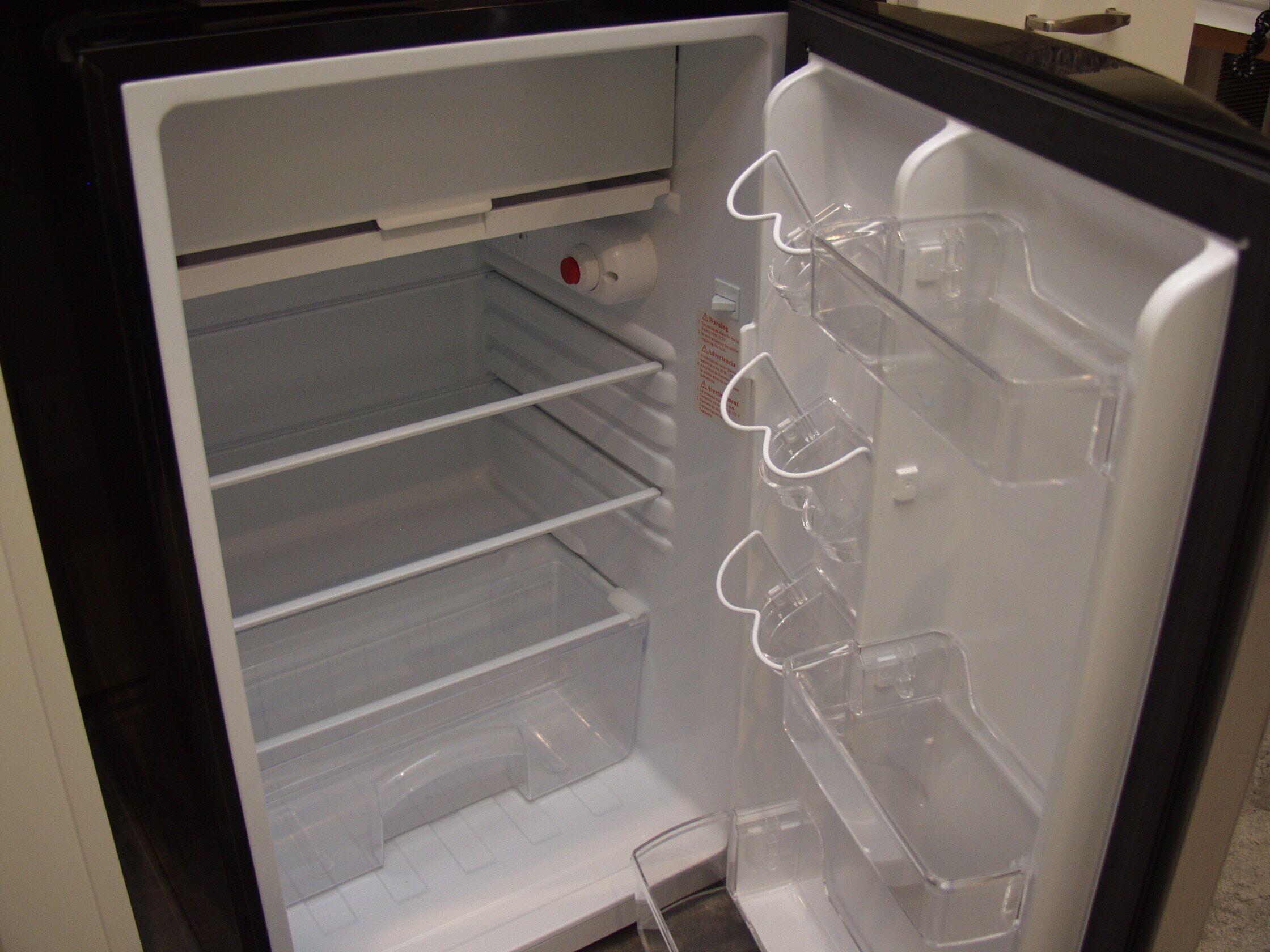 An open refrigerator with multiple shelves and a water dispenser.