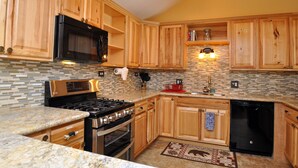 A kitchen with wooden cabinets, a black microwave, a gas stove, and a dishwasher. - Eagle's Ridge Lodge- 7 MIN WALK TO PEAK 9 & DOWNTOWN (Breckenridge)