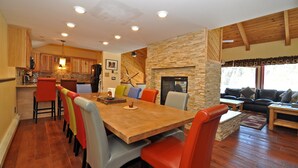A spacious living area with a wooden dining table, colorful chairs, a fireplace, and a cozy seating area with a sofa and coffee table. - Eagle's Ridge Lodge- 7 MIN WALK TO PEAK 9 & DOWNTOWN (Breckenridge)