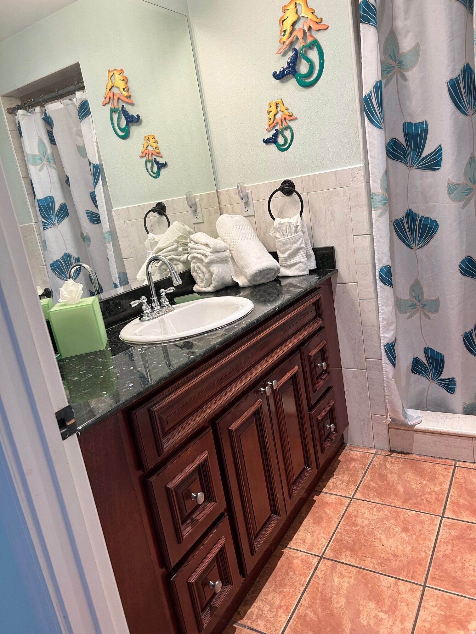 A bathroom with a white sink, dark wooden vanity, and a mirror.