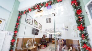 Un hall d’hôtel décoré d’un sapin de Noël, avec un espace salon et un panneau indiquant « CK Saigon Central ».