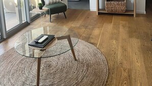 A modern living room with a glass coffee table, a sofa, a flat-screen TV, and a large window. - Centrepoint Units Heidelberg (Heidelberg)