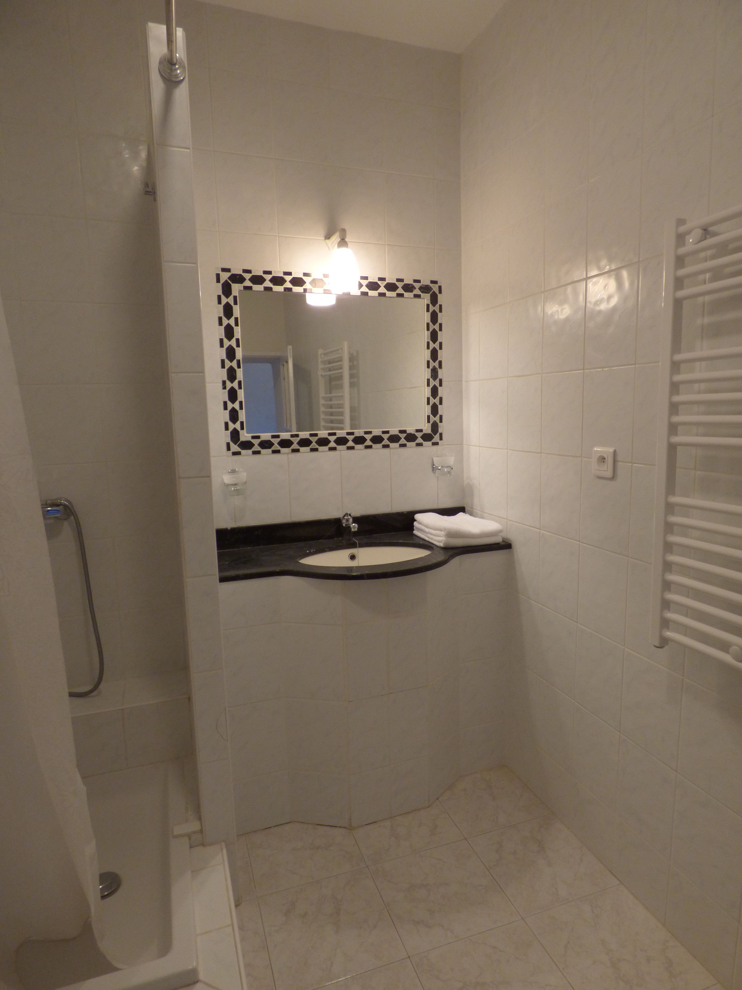 Un baño con lavamanos, espejo y ducha.