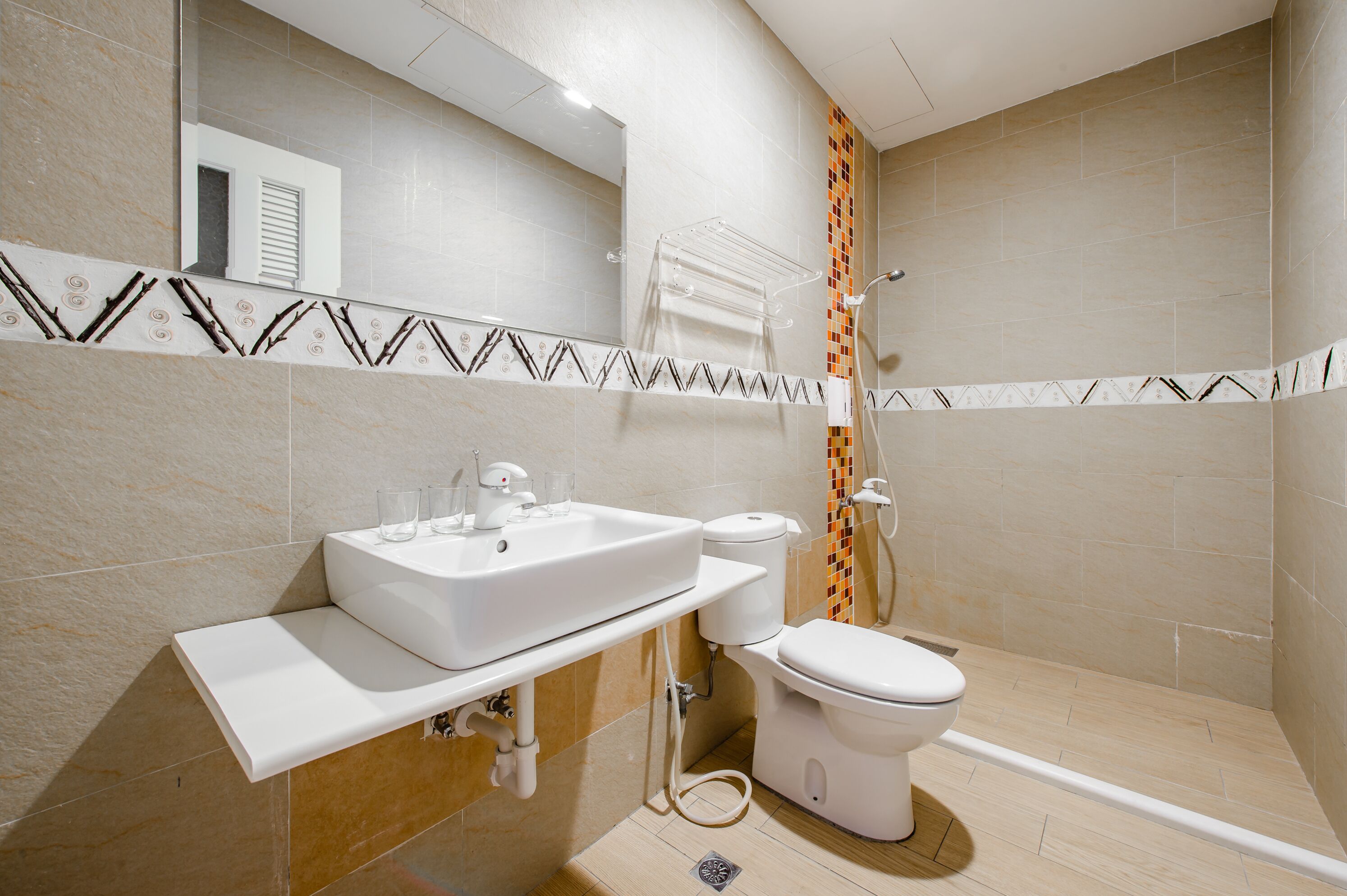 Un baño moderno con lavamanos, inodoro y ducha.