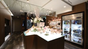 A reception area with a reception desk, a decorative centerpiece, and a refrigerator stocked with beverages. - Restay Onoji - Adults Only (Machida)